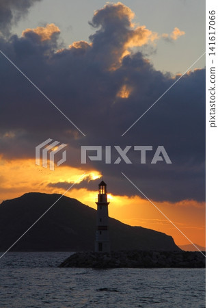 Seascape at sunshine. Lighthouse and sailings on the coast. Seaside town of Turgutreis and spectacular sunshine Seascape at sunshine. Lighthouse and sailings on the coast. Seaside town of Turgutreis and spectacular sunshine 141617066