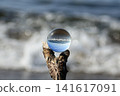 A glass ball reflecting the shoreline and the coastal scenery. 141617091