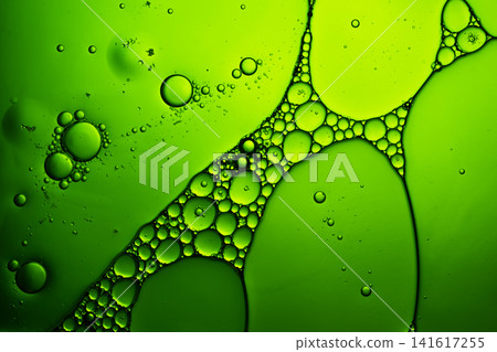 Oil and water separation forming a vibrant green bubble pattern surface Oil and water separation forming a vibrant green bubble pattern surface 141617255