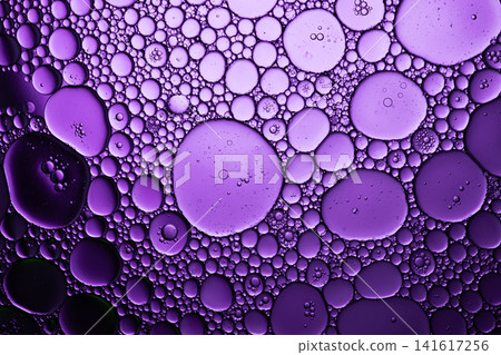 Oil and water separating creating purple bubbles and circles with an abstract pattern Oil and water separating creating purple bubbles and circles with an abstract pattern 141617256