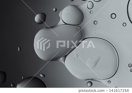 Oil drops and water creating an abstract monochrome background with merging circles Oil drops and water creating an abstract monochrome background with merging circles 141617288