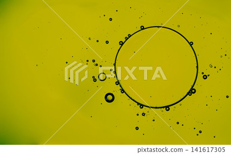Yellow liquid with dark oil drops and bubbles creating an abstract pattern Yellow liquid with dark oil drops and bubbles creating an abstract pattern 141617305