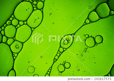 Oil drops and water creating an abstract green liquid pattern with bubbles Oil drops and water creating an abstract green liquid pattern with bubbles 141617573