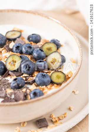 Healthy yogurt bowl with fresh blueberries granola and chia seeds in a rustic ceramic dish for a nutritious and delicious morning meal 141617628