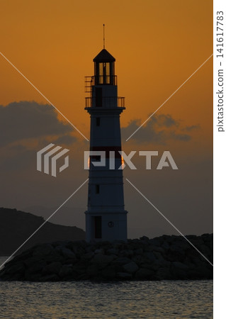 Seascape at sunshine. Lighthouse and sailings on the coast. Seaside town of Turgutreis and spectacular sunshine Seascape at sunshine. Lighthouse and sailings on the coast. Seaside town of Turgutreis and spectacular sunshine 141617783