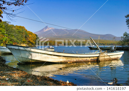 Autumn boat silhouette overlooking Mount Komagatake Autumn boat silhouette overlooking Mount Komagatake 141618197