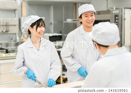 身穿廚師服的男女工作人員煮魚（廚師、廚師、菜市場、食物加工） 141619561