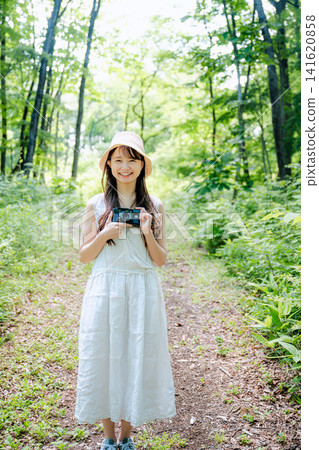 一位年輕女子在鬱鬱蔥蔥的森林中消磨時光 一位年輕女子在鬱鬱蔥蔥的森林中消磨時光 141620858