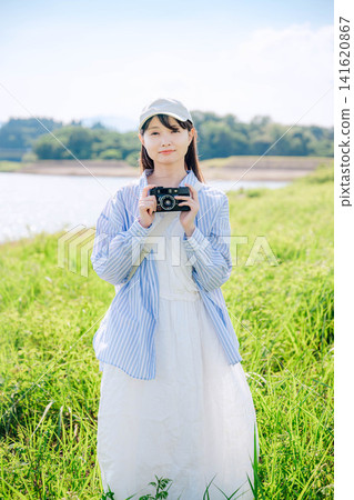 一位微笑的女士在公園裡享受拍照的樂趣。 141620867