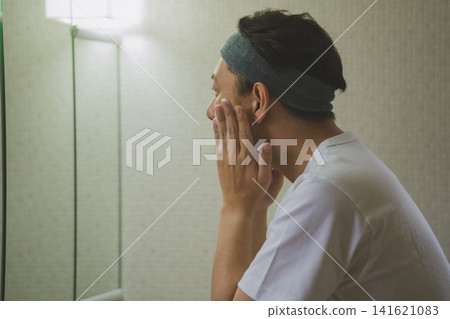 A middle-aged man washing his face A middle-aged man washing his face 141621083