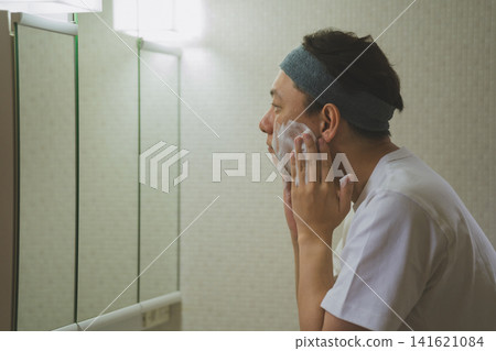 A middle-aged man washing his face A middle-aged man washing his face 141621084