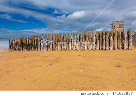 Traditional Wooden Wave Breakers on Sandy Beach at Low Tide in Saint Malo France Traditional Wooden Wave Breakers on Sandy Beach at Low Tide in Saint Malo France 141621937