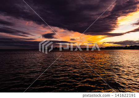 夕陽西下,灰濛濛的雲層與大海交相輝映。 夕陽西下,灰濛濛的雲層與大海交相輝映。 141622191