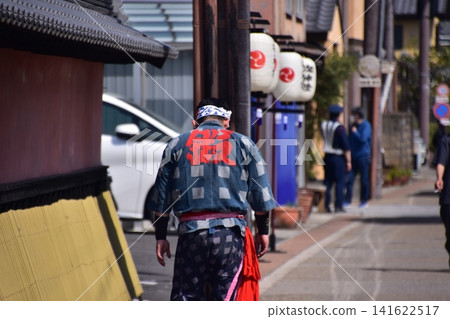 日本愛知縣犬山市：在犬山春季祭期間，一名身穿法被的男子走在街上，道路兩旁掛滿了燈籠。 141622517
