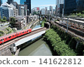 A railway scene in Ochanomizu, Tokyo, where the red Marunouchi Line train crosses the Kanda River and intersects with the JR Line. 141622812