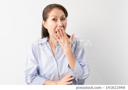 A senior woman in casual clothes standing – a lifestyle image. A senior woman in casual clothes standing – a lifestyle image. 141622949