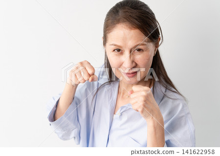 A senior woman in casual clothes standing – a lifestyle image. A senior woman in casual clothes standing – a lifestyle image. 141622958