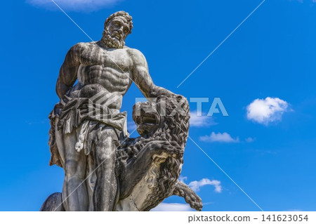 Classical Hercules Statue with Lion Against Blue Sky Classical Hercules Statue with Lion Against Blue Sky 141623054
