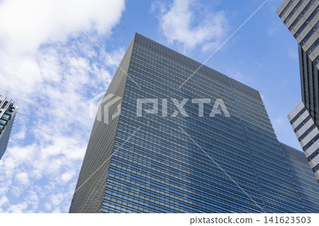 這棟現代辦公大樓的外觀以湛藍的天空和規則的百葉窗立面為特色。 這棟現代辦公大樓的外觀以湛藍的天空和規則的百葉窗立面為特色。 141623503