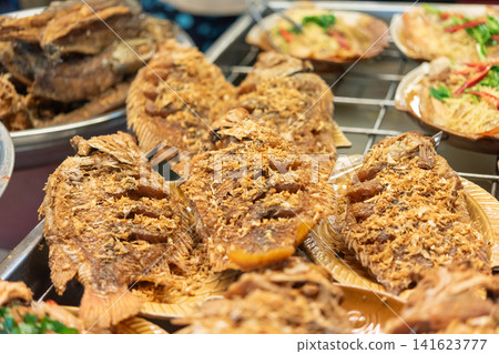 Crispy fried fish served plates aromatic herbs traditional Thai side dishes buffet style food setting Crispy fried fish served plates aromatic herbs traditional Thai side dishes buffet style food setting 141623777