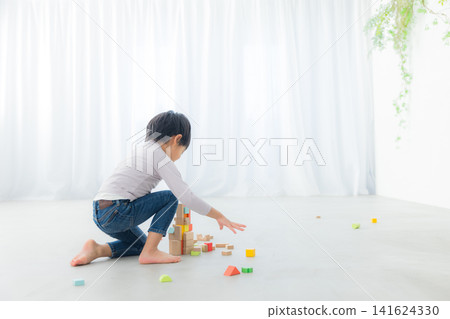 Boy playing with building blocks Boy playing with building blocks 141624330