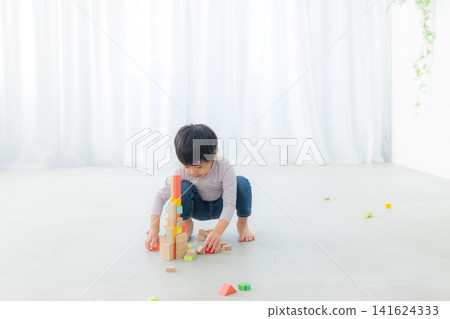 Boy playing with building blocks Boy playing with building blocks 141624333