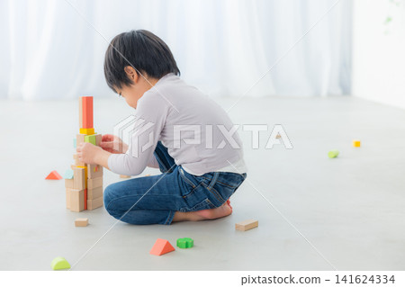 Boy playing with building blocks Boy playing with building blocks 141624334