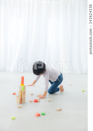 Boy playing with building blocks Boy playing with building blocks 141624336