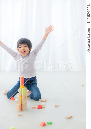 Boy playing with building blocks Boy playing with building blocks 141624338