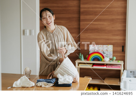 A mother preparing her child's belongings. 141624695