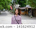 一位女士漫步在東京一處復古旅遊景點（深大寺附近的一條公共道路）的肖像。 141624912