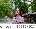 一位女士漫步在東京一處復古旅遊景點（深大寺附近的一條公共道路）。 141624913