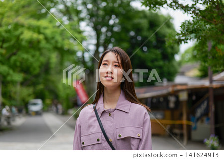 一位女士漫步在東京一處復古旅遊景點(深大寺附近的一條公共道路)。 一位女士漫步在東京一處復古旅遊景點(深大寺附近的一條公共道路)。 141624913