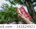 一位女士在東京一處復古旅遊景點（深大寺附近的一條公共道路）邊走邊吃團子（米糰子）的特寫鏡頭。 141624921