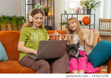 Mother daughter dog wireless earbuds music work on laptop sing duet track together focus family fun Mother daughter dog wireless earbuds music work on laptop sing duet track together focus family fun 141625299
