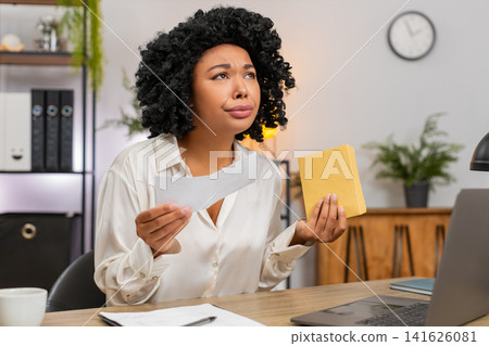 African American businesswoman reads letter frowns sad at tough email job rejection or lost chance African American businesswoman reads letter frowns sad at tough email job rejection or lost chance 141626081