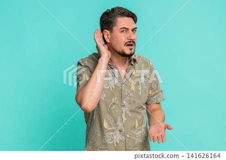 Adult man trying hear you looking confused and frowning, keeping arm near ear for louder voice Adult man trying hear you looking confused and frowning, keeping arm near ear for louder voice 141626164