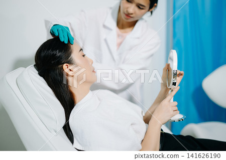 Doctor consulting patient in beauty clinic, skincare analysis, aesthetic treatment planning, professional advice, clean medical setting, modern cosmetic care Doctor consulting patient in beauty clinic, skincare analysis, aesthetic treatment planning, professional advice, clean medical setting, modern cosmetic care 141626190