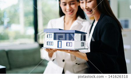 Real estate agent handing over house keys to a new homeowner, symbolizing property ownership transfer, successful home purchase and investment Real estate agent handing over house keys to a new homeowner, symbolizing property ownership transfer, successful home purchase and investment 141626318