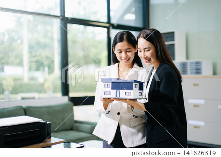 Real estate agent handing over house keys to a new homeowner, symbolizing property ownership transfer, successful home purchase and investment Real estate agent handing over house keys to a new homeowner, symbolizing property ownership transfer, successful home purchase and investment 141626319