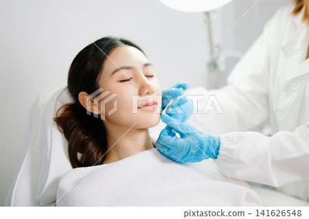 Dermatologist Injecting Botox or Facial Filler Treatment for Young Asian Woman at Aesthetic Clinic Dermatologist Injecting Botox or Facial Filler Treatment for Young Asian Woman at Aesthetic Clinic 141626548