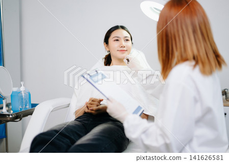 Doctor consulting patient in beauty clinic, skincare analysis, aesthetic treatment planning, professional advice, clean medical setting, modern cosmetic care Doctor consulting patient in beauty clinic, skincare analysis, aesthetic treatment planning, professional advice, clean medical setting, modern cosmetic care 141626581