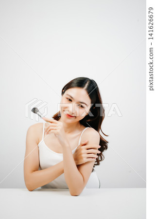 Asian woman holding lipstick with clean minimal style, soft light and natural beauty look for cosmetic advertising Asian woman holding lipstick with clean minimal style, soft light and natural beauty look for cosmetic advertising 141626679