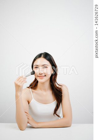 Asian woman holding lipstick with clean minimal style, soft light and natural beauty look for cosmetic advertising Asian woman holding lipstick with clean minimal style, soft light and natural beauty look for cosmetic advertising 141626729