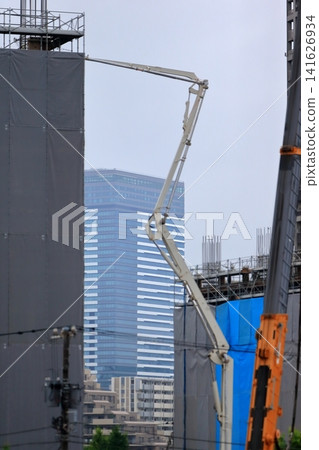 Concrete pouring to upper floors using a pump truck boom Concrete pouring to upper floors using a pump truck boom 141626934