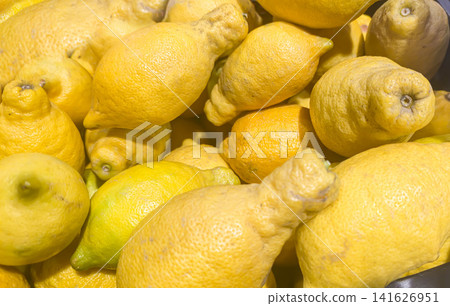 Ugly lemons in a wooden crate on a market counter. Supermarket counters. Ugly lemons in a wooden crate on a market counter. Supermarket counters. 141626951
