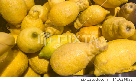 Ugly lemons in a wooden crate on a market counter. Supermarket counters. Ugly lemons in a wooden crate on a market counter. Supermarket counters. 141626952