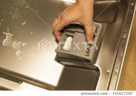 Woman closing dishwasher detergent dispenser door close up Woman closing dishwasher detergent dispenser door close up 141627207