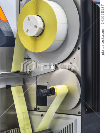 Machine operates with yellow tape for packaging at a factory in the morning Machine operates with yellow tape for packaging at a factory in the morning 141628187