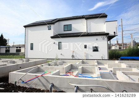 A newly built house that is one step away from completion and a detached house where foundation work has begun. A newly built house that is one step away from completion and a detached house where foundation work has begun. 141628289